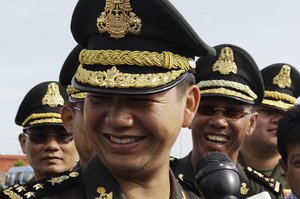 Lt. Gen. Hun Manet, foreground, smiles as his attends a Buddhist ceremony in Phnom Penh, Cambodia