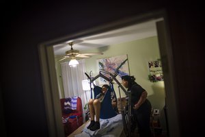 Jessica Guthrie uses a harness to lift her mother, Constance, off her bed and into a wheelchair to go to the living room in Fredericksburg, Va., on Monday, Sept. 19, 2022