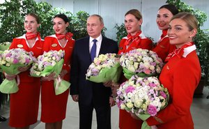 File - President of Russia Vladimir Putin with flight attendants of Russian flag carrier Aeroflot