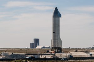 SpaceX Starship SN9 sitting on the launch pad with the build site in the background ahead of its test flight