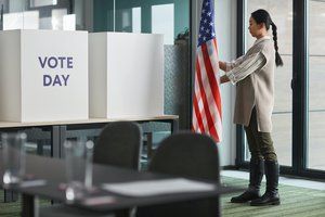 Election Day: Woman standing near the American flag