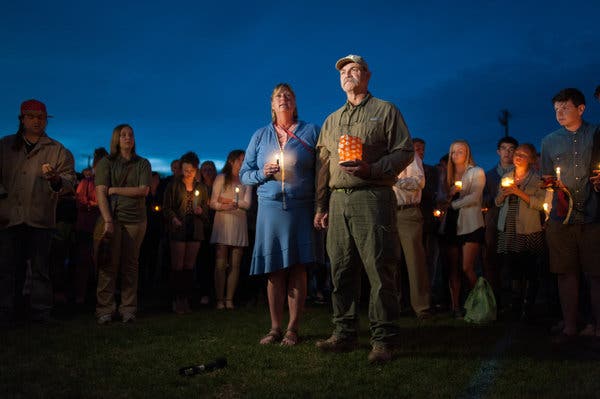 <strong>THE HOST FAMILY</strong> Kate Walker and Randy Smith, the host parents of Diren Dede, 17, at a vigil last week. &ldquo;This is not us,&rdquo; Mr. Smith said. &ldquo;It&rsquo;s not our neighborhood, it&rsquo;s not our country. It&rsquo;s not Montana.&rdquo;