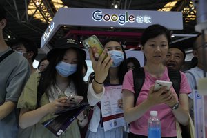 Visitors past near the Google booth during the 2023 World Artificial Intelligence Conference held in Shanghai, China, Thursday, July 6, 2023.