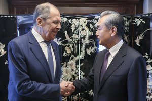 In this photo released by Russian Foreign Ministry Press Service, Russian Foreign Minister Sergey Lavrov, left, and Chinese Communist Party's foreign policy chief Wang Yi shake hands prior to their talks on the sideline of the ASEAN Post Ministerial Conference with Russia at the Association of Southeast Asian Nations (ASEAN) Foreign Minister's Meeting in Jakarta, Indonesia, Thursday, July 13, 2023