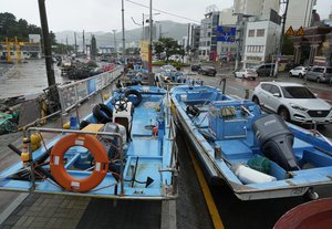 Fishing boats are placed along a road as the tropical storm named Khanun approaches to the Korean Peninsular, in Busan, South Korea, Wednesday, Aug. 9, 2023