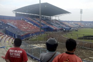 People examine the damage following a soccer match stampede at the Kanjuruhan Stadium in Malang, East Java, Indonesia, Sunday, Oct. 2, 2022