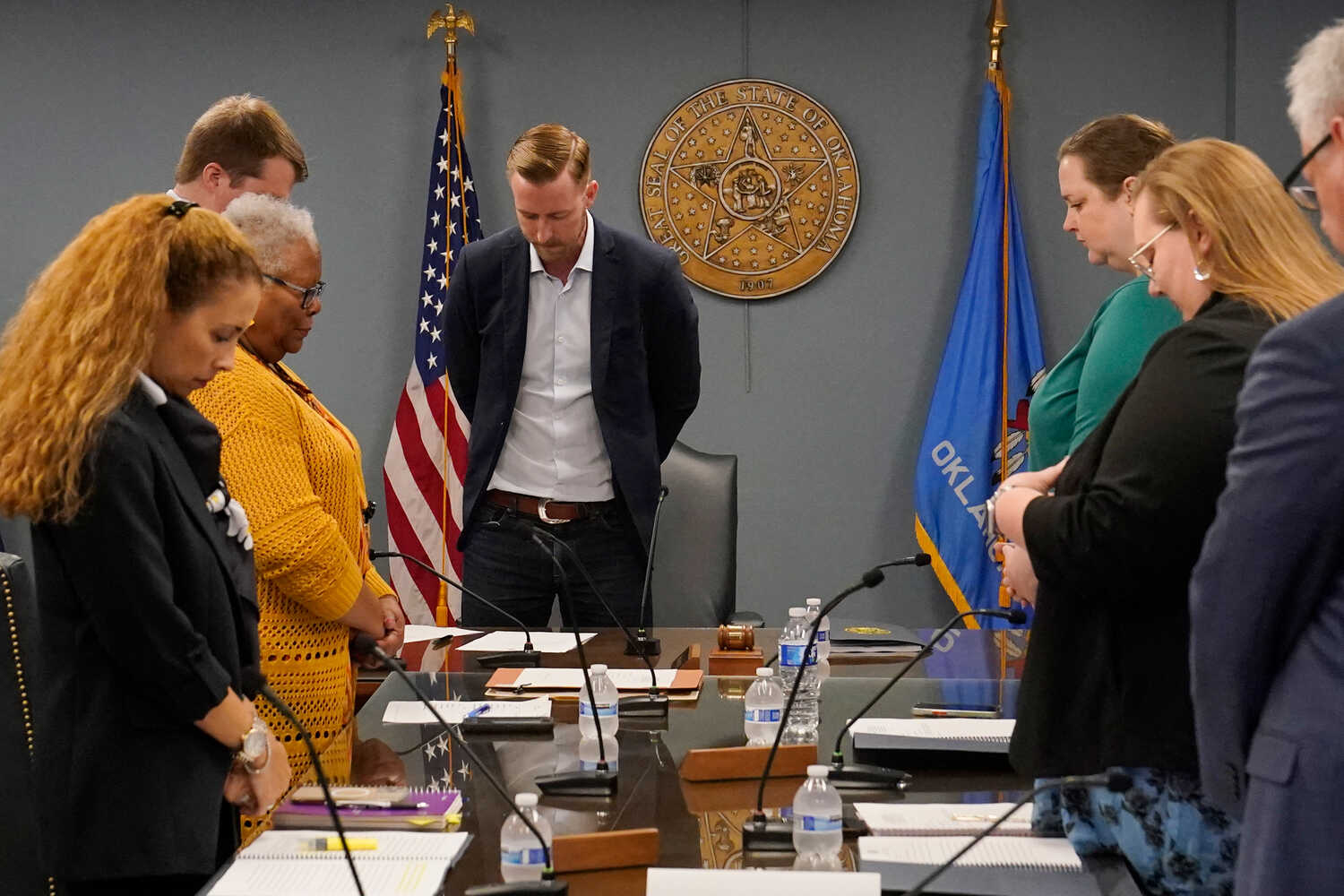 Ryan Walters, center, prays along with state board members during an April meeting in Oklahoma City.