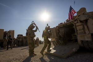 Crewmen enter Bradley fighting vehicles at a US military base at an undisclosed location in Northeastern Syria, Monday, Nov. 11, 2019.