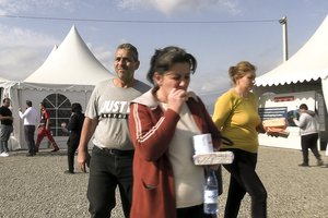 In this image taken from video, refugees from the first group of about 30 people from Nagorno-Karabakh arrive at Armenia's Kornidzor village in Syunik region, Armenia, Sunday, Sept. 24, 2023