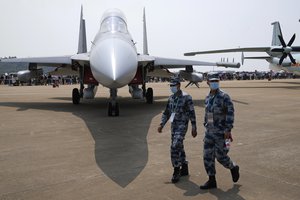 Chinese military personnel past by the J-16D electronic warfare airplane during 13th China International Aviation and Aerospace Exhibition, also known as Airshow China 2021