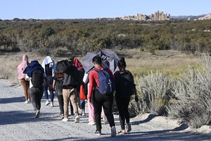 Asylum-seekers walk to a U.S. Border Patrol van after crossing the nearby border with Mexico, Tuesday Sept. 26, 2023.