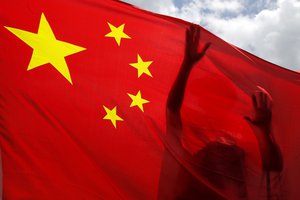 A pro-China supporter holds a Chinese national flag during a rally to celebrate the approval of a national security law for Hong Kong, in Hong Kong, Tuesday, June 30, 2020