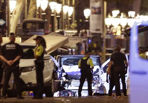 Police officers stand next to the van involved on an attack in Las Ramblas in Barcelona, Spain, Thursday, Aug. 17, 2017. A white van jumped up onto a sidewalk and sped down a pedestrian zone Thursday in Barcelona's historic Las Ramblas district, swerving from side to side as it plowed into tourists and residents. Police said 13 people were killed and more than 50 wounded in what they called a terror attack. (AP Photo/Manu Fernandez)