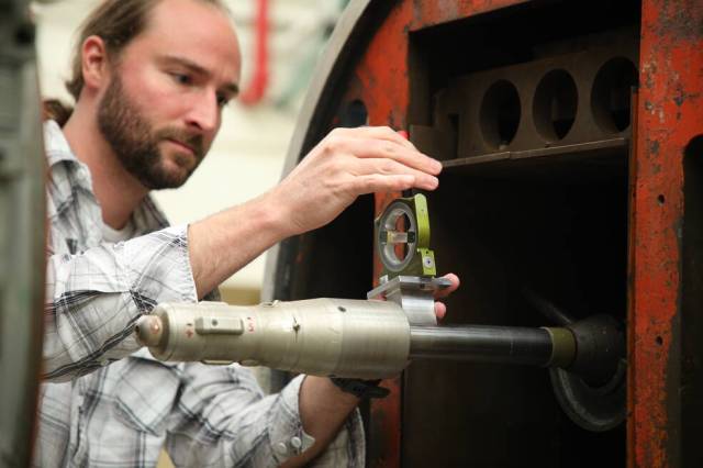 A man works on a scale model of the Mars Ascent Vehicle.