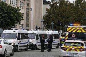 Police officers and rescue workers stand by the Gambetta high school after a man armed with a knife killed a teacher and wounded two others in Arras, northern France, Friday, Oct. 13, 2023