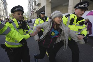 Environmental activist Greta Thunberg is taken away by police officers during the Oily Money Out protest outside the Intercontinental Hostel, in London, Tuesday, Oct. 17, 2023