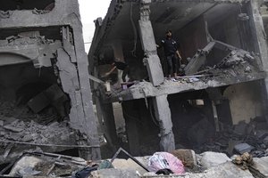 Palestinians look for survivors in a building destroyed in Israeli bombardment in Rafah refugee camp in Gaza Strip on Tuesday, Oct. 17, 2023.