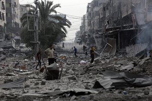 Palestinians inspect the damage of destroyed buildings following Israeli airstrikes on Gaza City, Friday, Oct. 27, 2023.