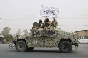 FILE - Taliban fighters patrol on the road during a celebration marking the second anniversary of the withdrawal of U.S.-led troops from Afghanistan, in Kandahar, south of Kabul, Afghanistan, on Aug. 15, 2023.