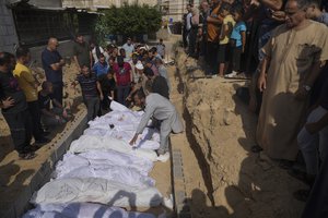 FILE- Palestinians bury the bodies of their relatives, killed in the Israeli bombardment of the Gaza Strip, Monday, Oct. 23, 2023, at a cemetery in Deir Al-Balah, Gaza,Palestinians say the devastating war between Israel and Hamas is robbing them not only of their loved ones but also of the funeral rites that long have offered mourners some dignity and closure in the midst of grief.