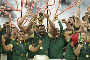 Siya Kolisi lifts the trophy as teammates celebrate after they won the Rugby World Cup final match between New Zealand and South Africa