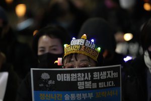 A woman attends a candlelight vigil for victims of Halloween crowd crush in Seoul, South Korea