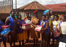 Chrispine Musimenta Rwaboona (on the left of the Police woman) delivering donations to inmates at Ndorwa Prison in Kabale