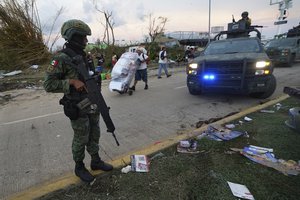 Soldiers guard the streets while residents take items from local stores after Hurricane Otis ripped through Acapulco, Mexico, on Thursday, October 26, 2023. after Hurricane Otis ripped through Acapulco, Mexico, on Thursday, October 26, 2023