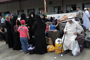 Palestinian families wait outside the terminal at the Rafah border crossing in the southern Gaza Strip on September 28, 2013