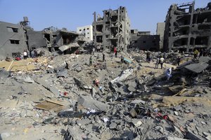 Palestinians wander among debris of buildings that were targeted by Israeli airstrikes in Jabaliya refugee camp, northern Gaza Strip, Wednesday, Nov. 1, 2023.