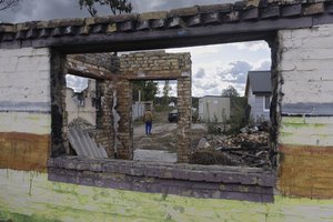 File - A man passes his destroyed house in Moshchun, near Kyiv, Ukraine, Tuesday, Oct. 10, 2023. Many Ukrainians are expecting the same or worse this coming winter and have spent months preparing, including collecting firewood and buying generators.