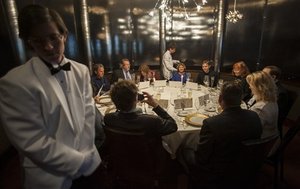 Servers Zack Black, left, and Evan Boyle, center, tend to guests during a re-creation of the final first class dinner served on the RMS Titanic, Saturday, April 14, 2012, in Houston.