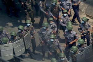 FILE - Police and soldiers armed with guns and slingshots advance towards anti-coup protesters in Mandalay, Myanmar, Wednesday, March 3, 2021. The prospects for peace in Myanmar, much less a return to democracy, seem dimmer than ever two years after the army seized power from the elected government of Aung San Suu Kyi, experts say.