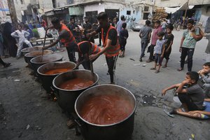 Palestinians cook during the ongoing Israeli bombardment of the Gaza Strip in Rafah on Monday, November 13, 2023.