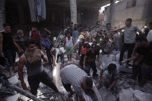 Palestinians look for survivors under the rubble of a destroyed house following an Israeli airstrike in Khan Younis refugee camp, southern Gaza Strip, Monday, Nov. 13, 2023