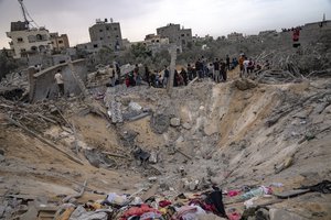 Palestinians look for survivors following an Israeli airstrike in Khan Younis, southern Gaza Strip, Sunday, Nov. 12, 2023.