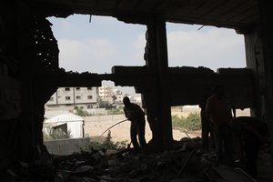 File - Palestinians inspect the damage following an Israeli air strikes on Rafah town in the southern Gaza Strip.