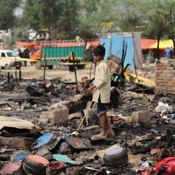 A young boy searches for his belongings after a fire at a Rohingya refugee camp in New Delhi in June 2021