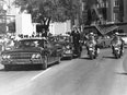 Black and white photograph of President John F. Kennedy's motorcade in Dallas, Texas prior to his assassination. 