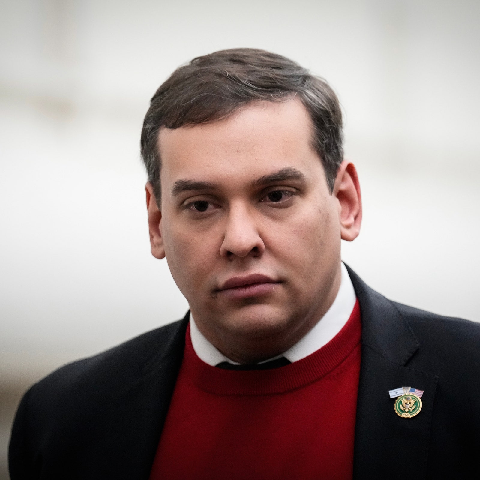 George Santos in a red sweater and black jacket.