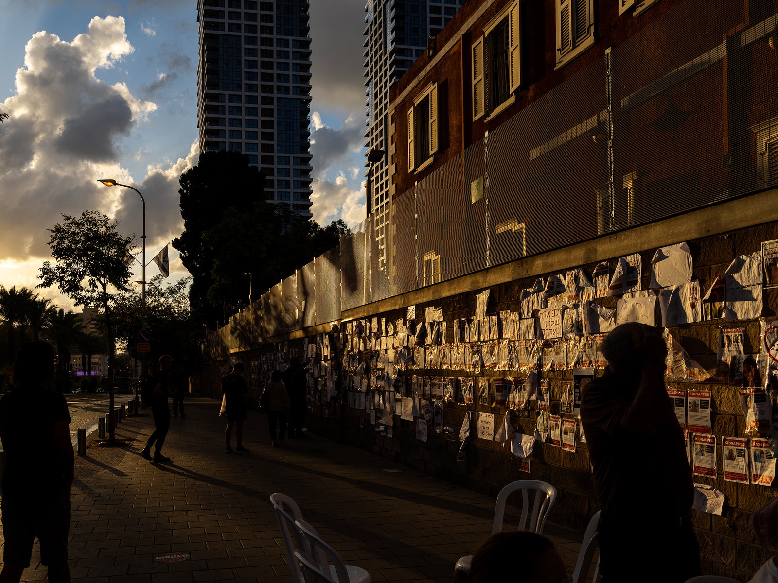 People standing in front of a wall covered in posters.