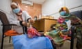 A female doctor examines the swollen foot of an older woman