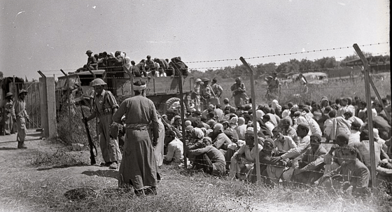 Arab men behind barbed wire fence before being expelled from Ramle (Image: Benno Rothenberg/Meitar Collection/National Library of Israel)