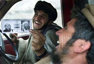 File - Returning from the frontline in the White Mountains near Tora Bora, Afghan anti-al-Qaida fighters share a laugh as they hold up a leaflet they found with the images of top al-Qaida officials Osama bin Laden and Zawahiri reading "25 Million Dollar Reward" Monday Dec. 17, 2001. Afghan militia leaders declared victory in the battle of Tora Bora claiming to have captured al- Qaida's last base but the whereabouts of bin Laden and Zawahiri are still unknown.