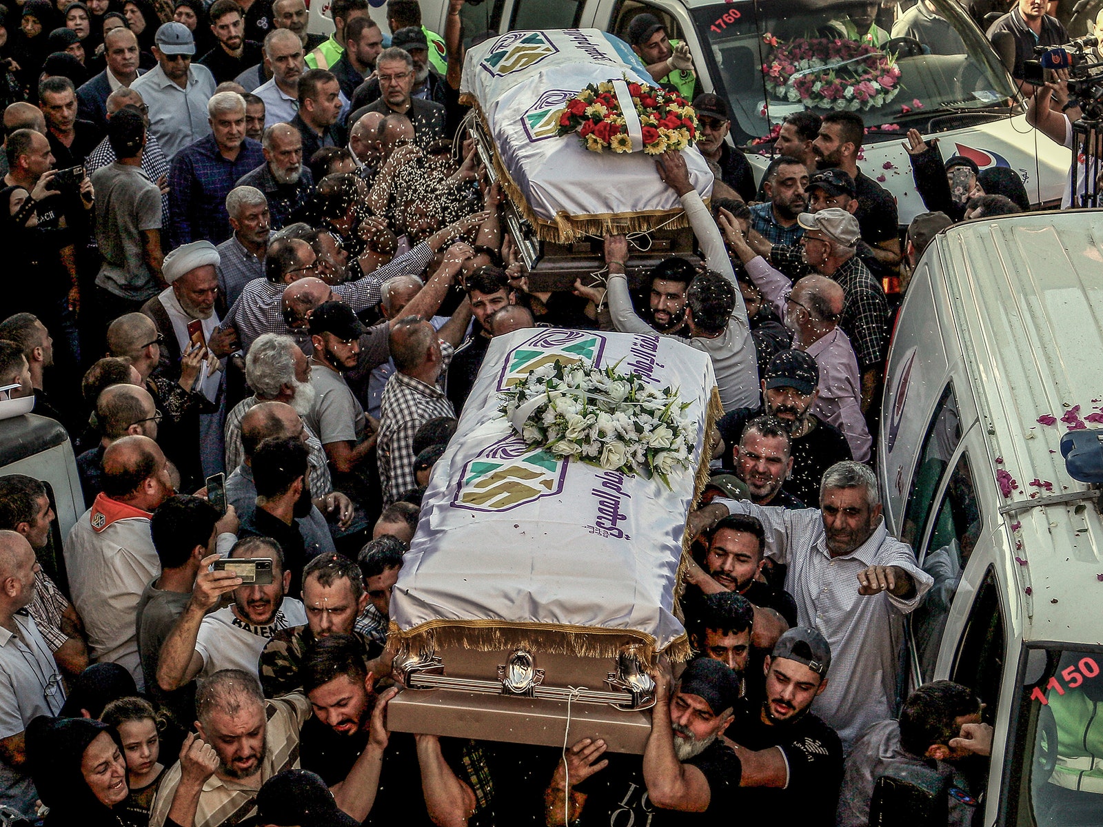 Mourners throw rice over the coffins of three sisters killed along with their grandmother in an Israeli strike.