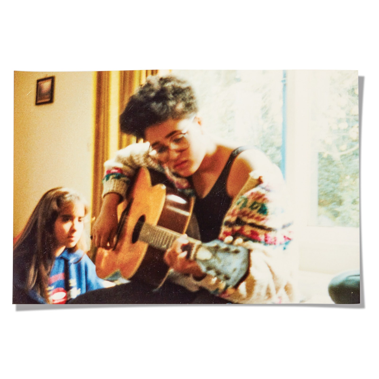 A scan of a photograph of Zadie Smith in her youth holding a guitar.