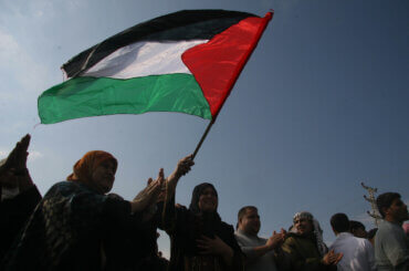 Palestinians wave the Palestinian flag (Photo: APA Images)