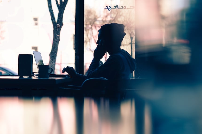 A man sitting in a cafe writing on a laptop. (Photo by Hannah Wei.)