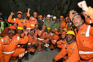 This handout photo provided by the Uttarakhand State Department of Information and Public Relations shows rescue workers cheer, along with Pushkar Singh Dhami, Chief Minister of Uttarakhand state, center wearing white helmet, and Indian Minister of State of Road Transport and Highways V.K. Singh, center right, in the northern Indian state of Uttarakhand, India, Tuesday, Nov. 28, 2023