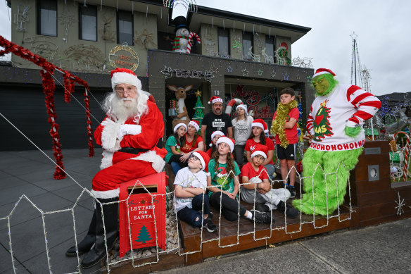 Friends of Renee Gaitanis (centre rear in grey jumper) gather outside her Wollert home on Thursday evening after the council rejected her initial plan for a Christmas extravaganza, saying it was in breach of environmental protection regulations.